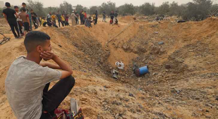 Palestinians gather around a huge crater following “Israeli” bombardment in Rafah, south Gaza. (April 18, 2024) (Photo: Mohammed Abed/AFP) 