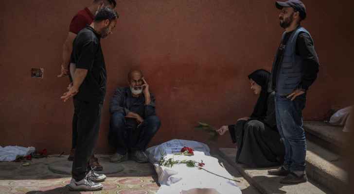 People mourn by the body of a missing relative which was unearthed at Nasser Hospital in Khan Yunis. (April 23, 2024) (Photo: AFP) 