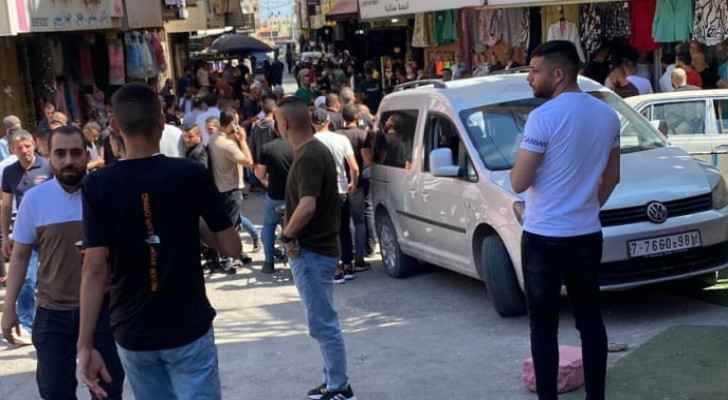 Palestinians gather in front of the shop from which Amer Masharqa was kidnapped