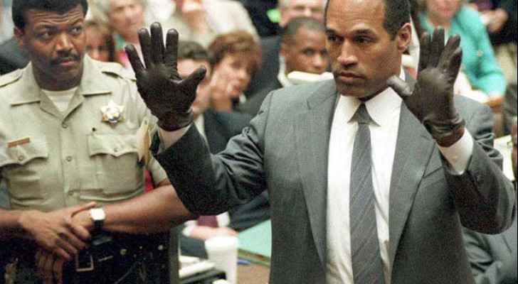 O.J. Simpson sizing up the infamous gloves in the courtroom. 
