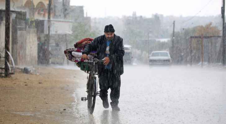  A displaced Palestinian man pushes a bicycle bearing his belongings in the rain in Rafah in the southern Gaza Strip (May 6, 2024) (Photo: AFP) 