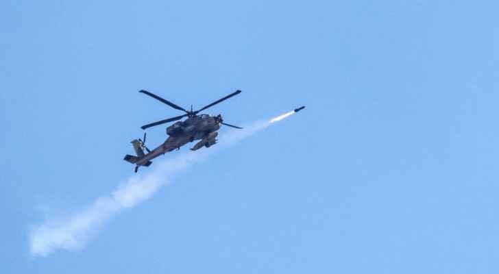 An “Israeli” Air Force attack helicopter firing a missile while flying over the Gaza Strip. (May 15, 2024) (Photo: AFP) 