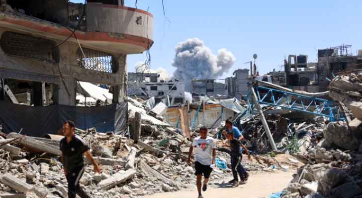 Palestinians walking through their destroyed homes.