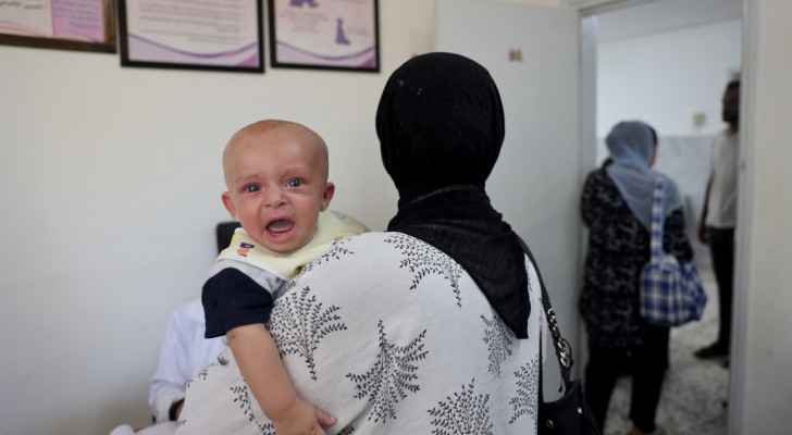 Mother carries her crying infant during its check-up at a Clinic in Deir al-Balah, central Gaza Strip. (June 26, 2024) (Photo: AFP)