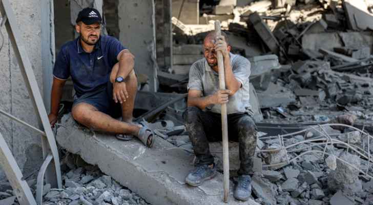Palestinians sitting on the rubble.