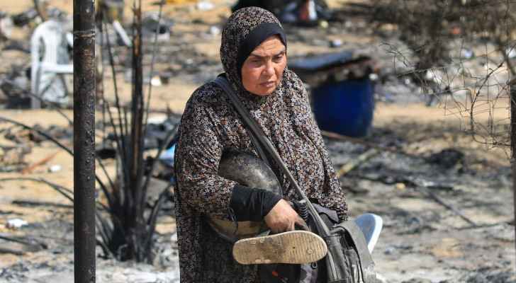 A woman carries salvaged items following an “Israeli” raid in al-Mawasi area in Rafah on south Gaza. (June 29, 2024) (Photo: AFP)