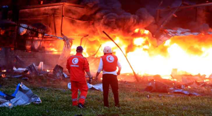 Civil defence workers check a burning warehouse targeted by “Israeli” strikes in Ghazieh, Lebanon, Monday. (Feb. 19, 2024) (Photo: AP) 