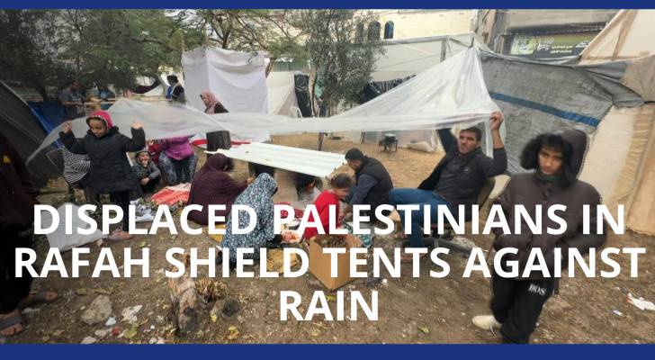Displaced Palestinians in Rafah shield tents against rain