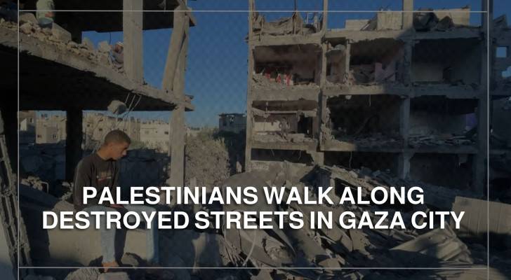 Palestinians walk along destroyed streets in Gaza City